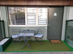 a table and two chairs on a porch with a window at Superbe studio 2** rénové a neuf idéalement placé in Aix-les-Bains