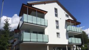 biały budynek z niebieskimi balkonami w obiekcie Stadtdomizil TOP 5 w Schladming