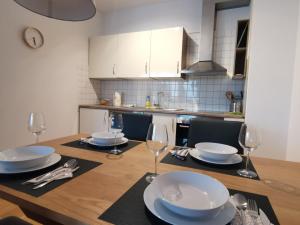 a kitchen with a table with plates and wine glasses at Apartma Rožmarin Bohinj in Bohinj
