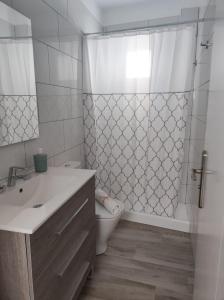 Un baño con lavabo, inodoro y ducha. en CASA PIRÁMIDE 3. Terraza WiFi y Parking Privado, en Icod de los Vinos 28 fotos más