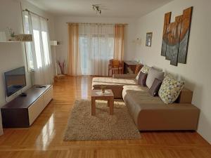 een woonkamer met een bank en een tv bij Apartment Tomas,,,Spacious house with private parking,terrace,5G Internet,,,,, in Zadar