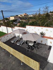 un patio con dos mesas y dos sombrillas en CASA PIRÁMIDE 3. Terraza WiFi y Parking Privado, en Icod de los Vinos