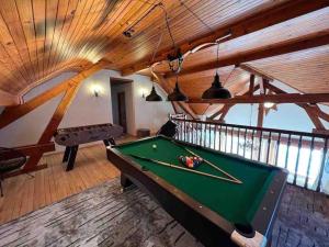 a pool table in a room with wooden ceilings at EVASION gîtes et spa in Saint-Léonard