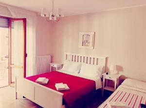 um quarto com uma cama com um cobertor vermelho em B&B Casa Dolce Casa Monopoli em Monopoli