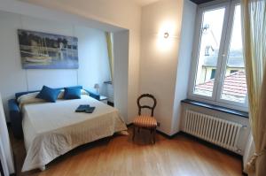 a bedroom with a bed and a window and a chair at La casa di Fede e Fran in Camogli