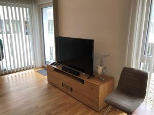 salon z telewizorem z płaskim ekranem i krzesłem w obiekcie Stadtdomizil TOP 5 w Schladming