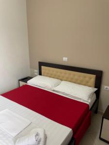1 Schlafzimmer mit 2 Betten mit roter und weißer Bettwäsche in der Unterkunft Xhonis Apartments in Ksamil