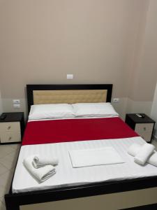 a bedroom with a bed with white towels on it at Xhonis Apartments in Ksamil
