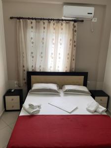 a bedroom with a large bed with a red blanket at Xhonis Apartments in Ksamil
