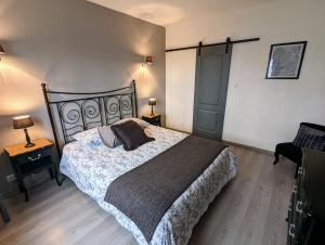 1 dormitorio con 1 cama grande y 1 silla en La Maison de Boyeux, en Châtillon