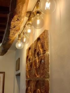ein Zimmer mit einer Steinmauer mit Licht in der Unterkunft Maidalchini House in Acquapendente