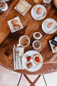 a wooden table with plates of food on it at Les Maisons Du Sud in Saint-Tropez