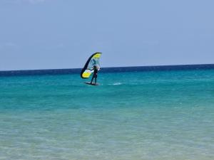 osoba na desce surfingowej z żaglem w oceanie w obiekcie HATO Holiday Home Fuerteventura w mieście Costa Calma