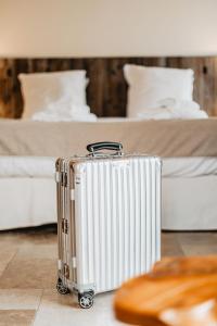 a suitcase sitting on the floor next to two beds at Les Maisons Du Sud in Saint-Tropez
