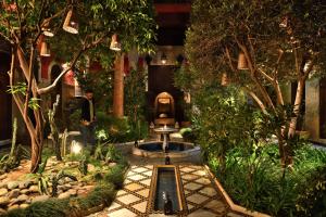 a garden with a fountain in the middle of a building at Riad L'Aziza in Marrakesh