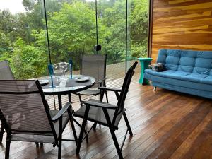 a room with a table and chairs and a couch at Sítio Hortênsias in Três Coroas