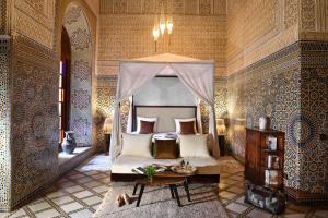 1 dormitorio con 1 cama y 1 mesa en una habitación en Riad L'Aziza, en Marrakech