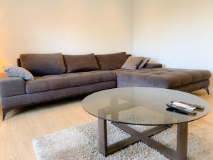 ein Wohnzimmer mit einem Sofa und einem Glastisch in der Unterkunft G Apartment in Podstrana