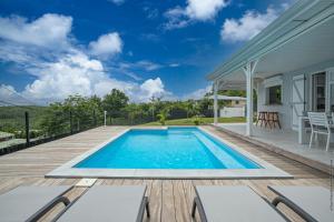a swimming pool on a deck with a house at Villa Kaliemma in Le Marin