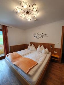 una camera da letto con un letto grande con un lampadario di Der Brückenhof Ramsau a Ramsau am Dachstein Altre 37 foto
