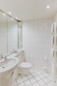een witte badkamer met een toilet en een wastafel bij Hotel-Restaurant Zum Schwanen in Wermelskirchen