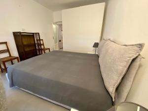 ein Schlafzimmer mit einem großen Bett und einem Kissen in der Unterkunft Appartamento GERANIO in Riva Trigoso