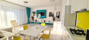 uma sala de estar com uma mesa branca e cadeiras amarelas em Apartament Blue Sea em Mamaia Nord – Năvodari