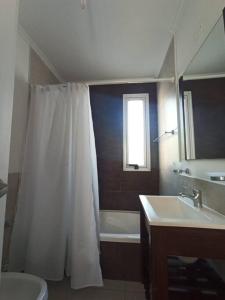 a bathroom with a white shower curtain and a sink at Lust 270 in Aldea Camarero