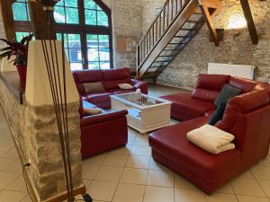 a living room with red couches and a staircase at Maison Belles Pierres in Montagny-lès-Beaune