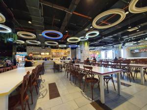 un restaurante con mesas y sillas y gente en él en Lovely Vivacity Jazz suite 2 Cozy Condo 2 Card LV7, en Kuching