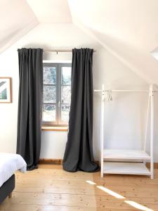 1 dormitorio con cortinas grises y ventana en Ferienwohnung Weingut Villa Huesgen am Mönchhof, en Traben-Trarbach