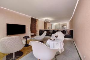 een woonkamer met witte stoelen en een tv bij Lxfactory Terrace Lisbon Loft in Lissabon