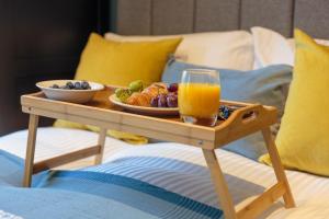 a tray of food and a glass of orange juice on a bed at Lovely apartment beneath Edinburgh Castle in Edinburgh