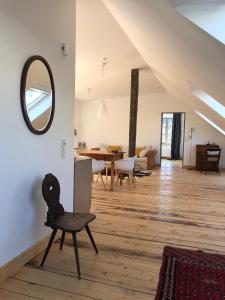 ein Wohnzimmer mit einem Spiegel und einem Stuhl in der Unterkunft Ferienwohnung Weingut Villa Huesgen am Mönchhof in Traben-Trarbach