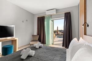 a hotel room with a bed and a tv and a bedroom at Sarah Luxury Rooms in Syvota