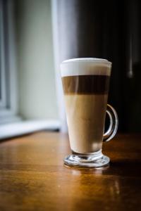 a cup of coffee sitting on a wooden table at The Roundabout Hotel in Pulborough