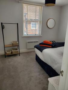 a bedroom with a bed and a mirror and a window at Ipswich Town Centre - Apartment 6 in Ipswich