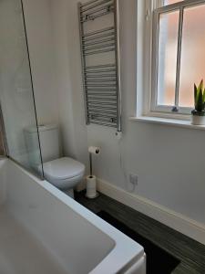 a white bathroom with a toilet and a window at Ipswich Town Centre - Apartment 6 in Ipswich