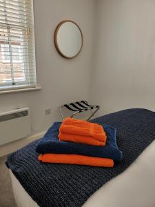 a pile of towels on a bed with a mirror at Ipswich Town Centre - Apartment 6 in Ipswich