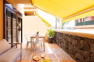 balkon ze stołem i krzesłami na budynku w obiekcie Sunnyland Apartment Costa Silencio parking w Aronie