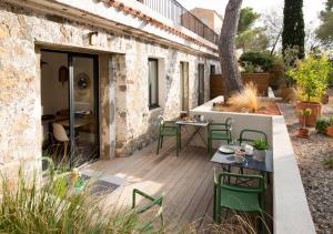 een patio met groene stoelen en tafels voor een gebouw bij Beija Flor in Agay - Saint Raphael