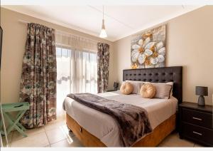 a bedroom with a large bed and a window at The Blyde in Pretoria
