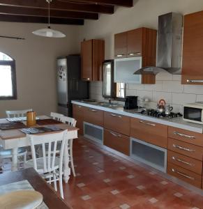 a kitchen with wooden cabinets and a table and a kitchen with a dining room at Casa vacanze Villa Liù in Sciacca