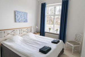 a bedroom with a bed and a chair and a window at Hotell Villa Rönne in Ängelholm