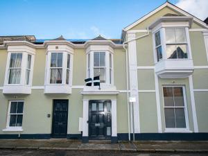 a yellow house with black doors and windows at Thomas Chambers in Camborne