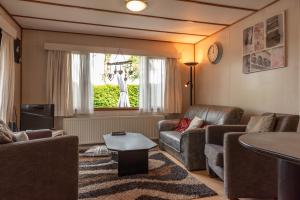 a living room with a couch and a table at Huisje Mooijweer in Putten