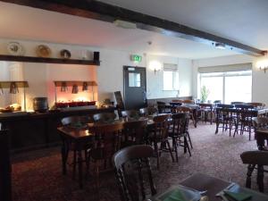 a restaurant with tables and chairs in a room at The River Don Tavern and Lodge in Crowle