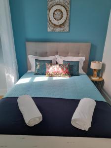 a blue bedroom with a large bed with two pillows at Casa Chanel in Figueira da Foz +53 photos