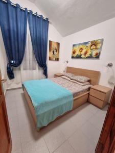 sypialnia z łóżkiem i niebieskimi zasłonami w obiekcie HATO Holiday Home Fuerteventura w mieście Costa Calma +37 zdjęć