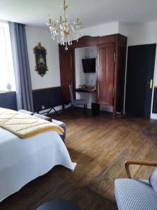 1 dormitorio con cama y lámpara de araña en La Ménardière "Tranquilitatis" Chambre double petit déjeuner compris, en Corseul